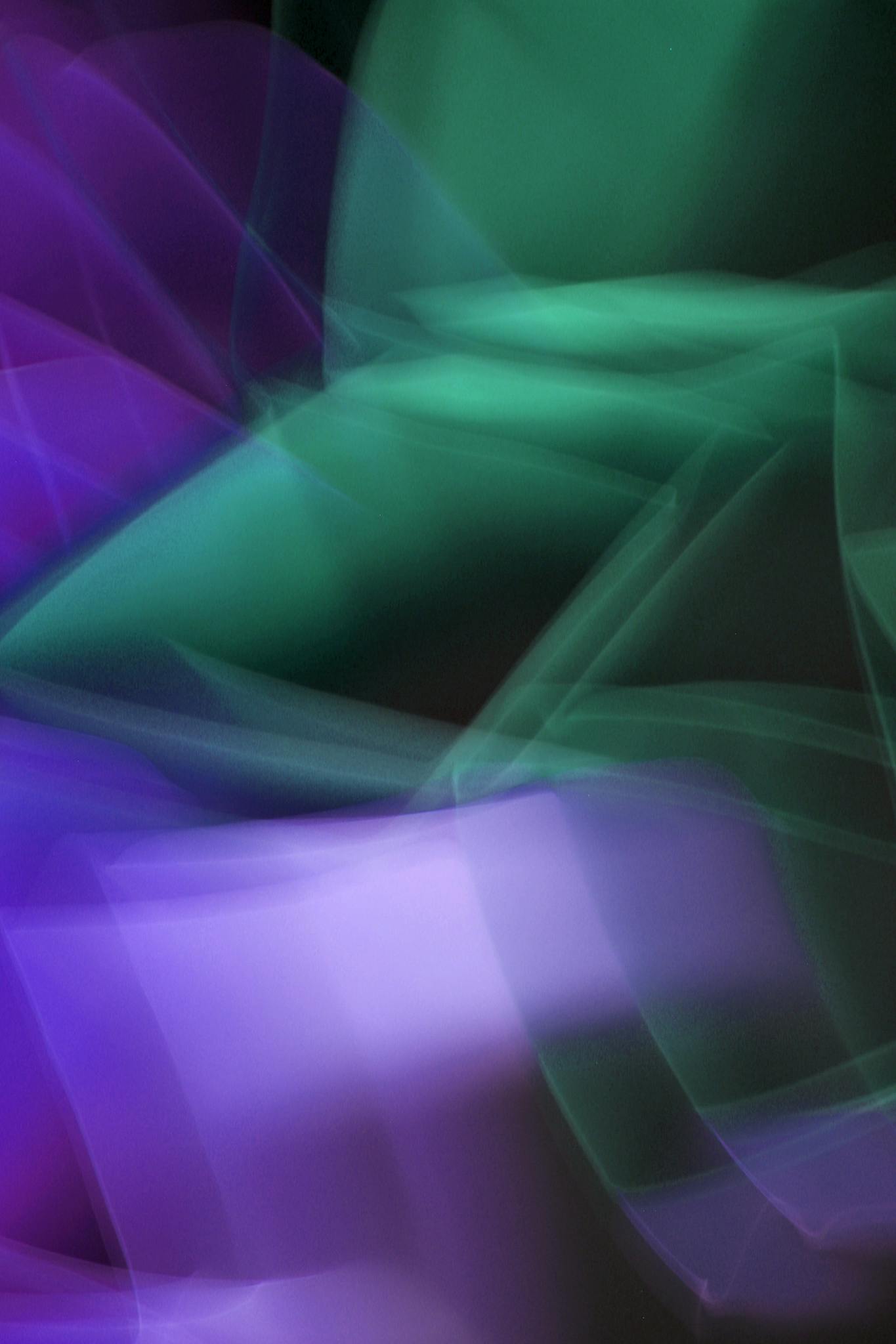 Abstract light painting with green and purple hues creating a dynamic and artistic effect.