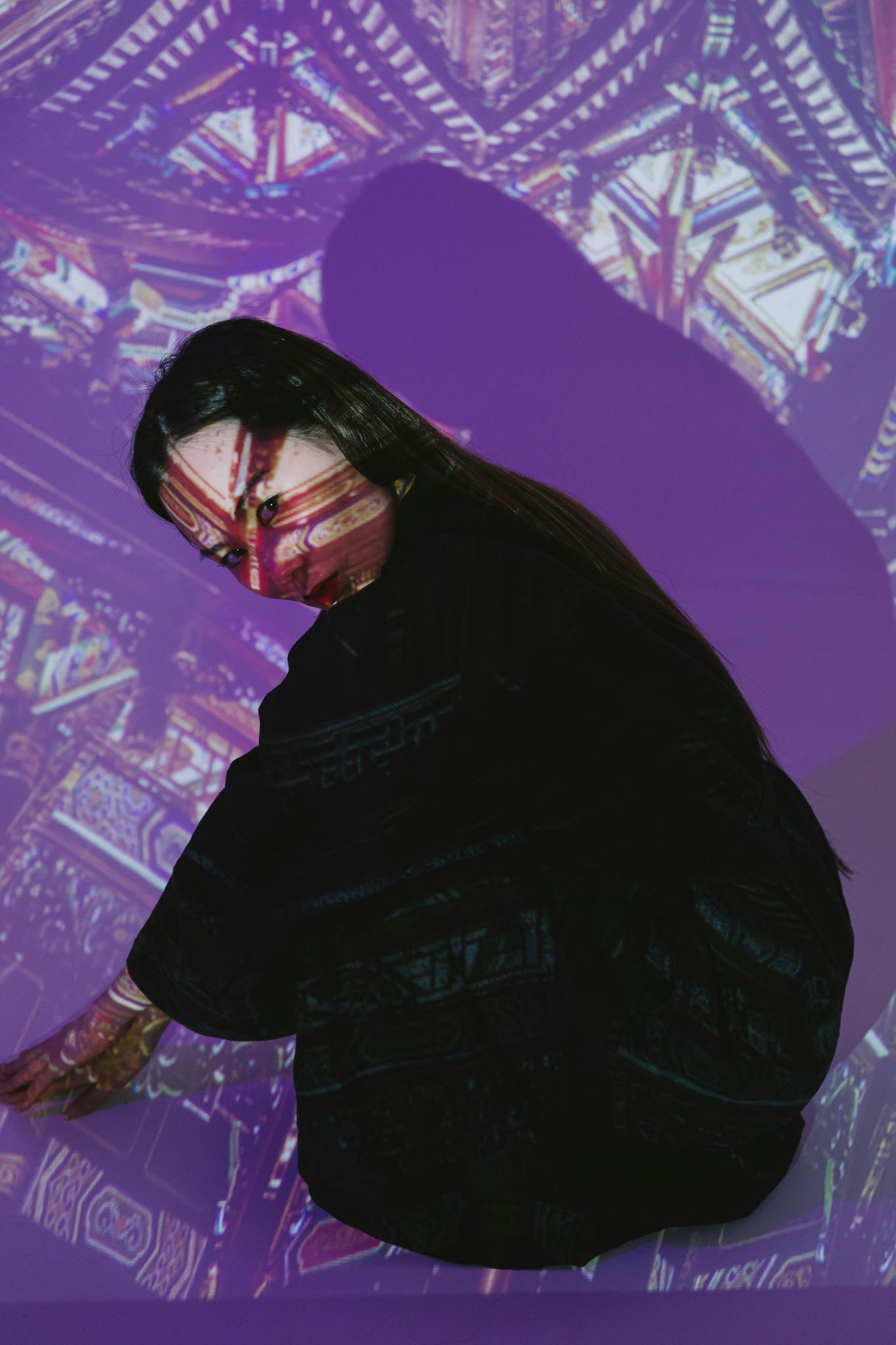 Artistic portrait of a woman with intricate light projections on her face.